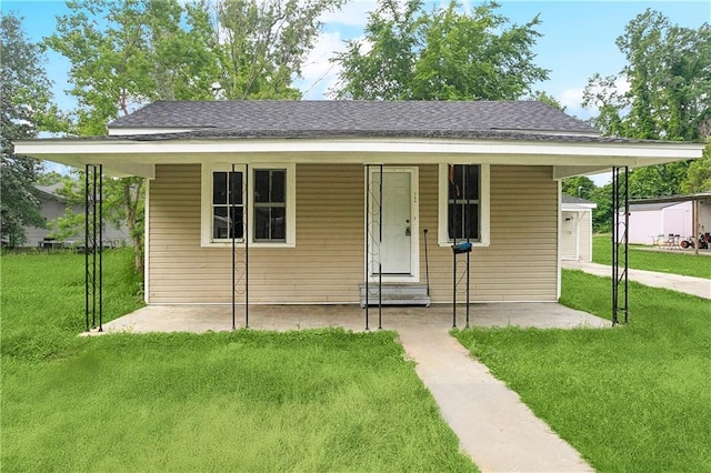 bungalow-style house with roof with shingles and a front yard