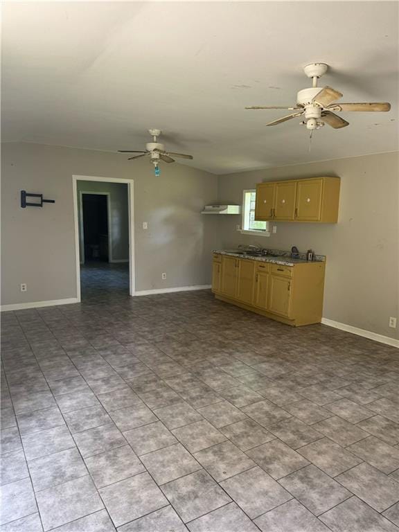 kitchen with a ceiling fan, baseboards, and light brown cabinets