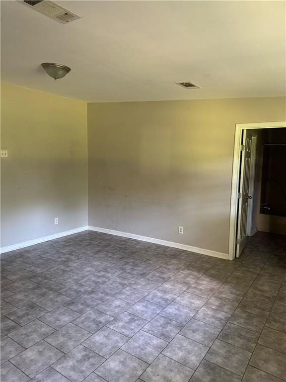 unfurnished room with visible vents and baseboards