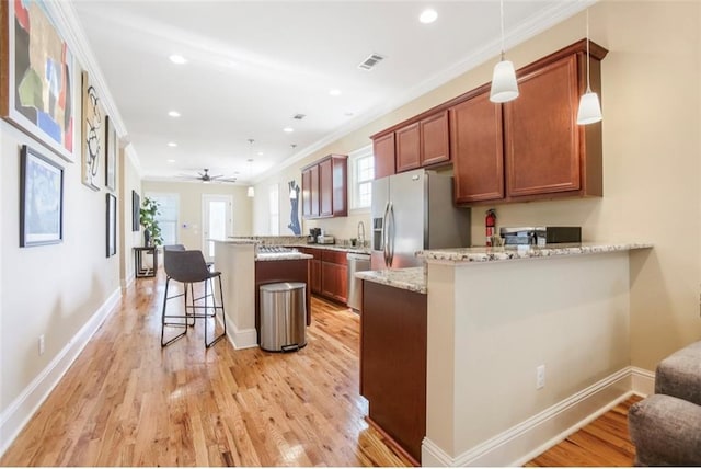 2608 Republic St, New Orleans, LA 70119 - kitchen with stainless steel appliances, a peninsula, ornamental molding, light wood-style flooring, and recessed lighting