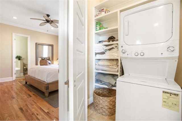2608 Republic St, New Orleans, LA 70119 - washroom with stacked washer and clothes dryer, ornamental molding, a ceiling fan, baseboards, and light wood-style flooring