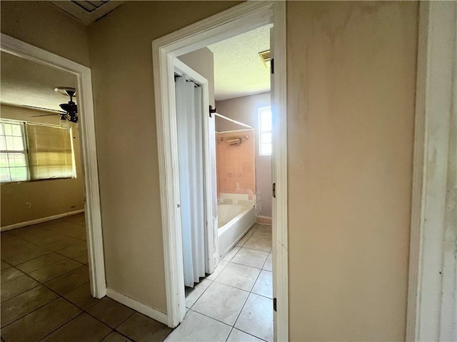 2221 Annette St, New Orleans, LA 70119 - hallway featuring light tile patterned floors, baseboards, and a textured ceiling