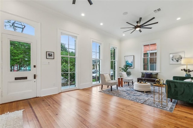 interior space featuring crown molding, a ceiling fan, baseboards, recessed lighting, and hardwood / wood-style flooring