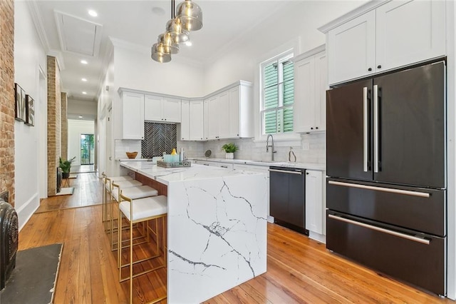 kitchen featuring plenty of natural light, ornamental molding, a sink, and black appliances