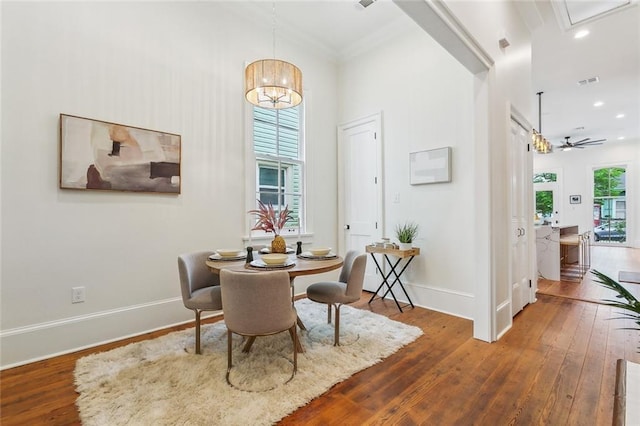 dining space featuring crown molding, a chandelier, recessed lighting, baseboards, and hardwood / wood-style flooring