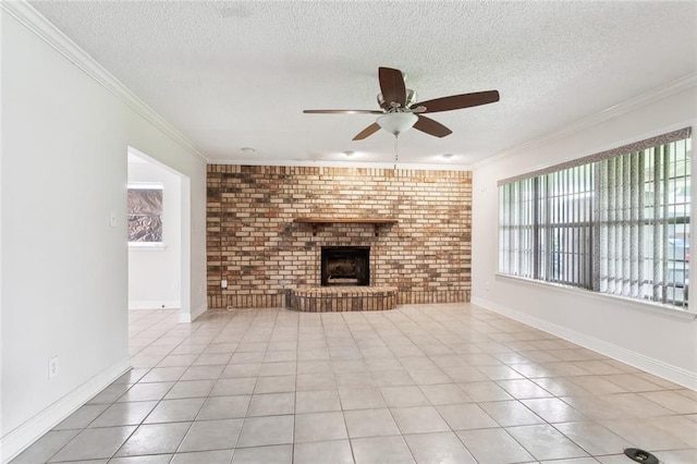 unfurnished living room with crown molding, a brick fireplace, a textured ceiling, a ceiling fan, and light tile patterned floors