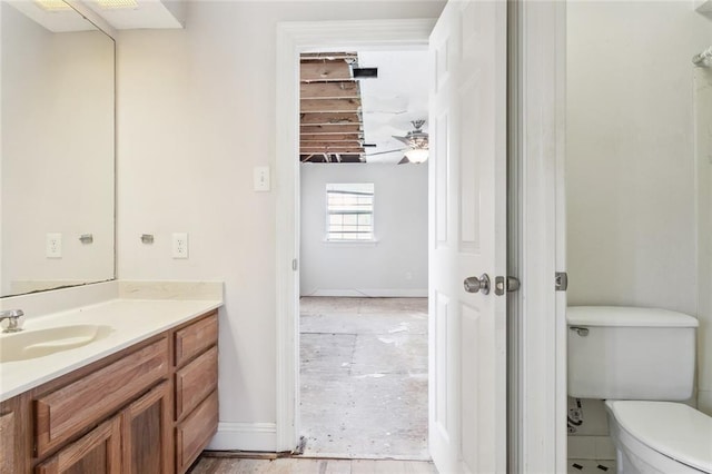 bathroom with baseboards, toilet, and vanity