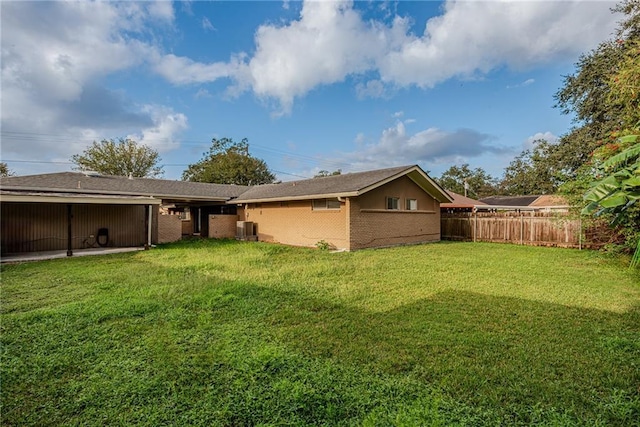 rear view of property featuring fence, a yard, and cooling unit