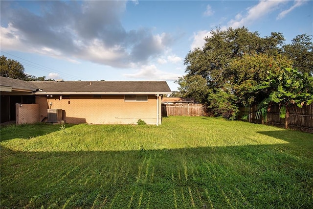 view of yard with central air condition unit and a fenced backyard