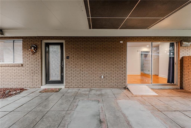 view of exterior entry featuring brick siding