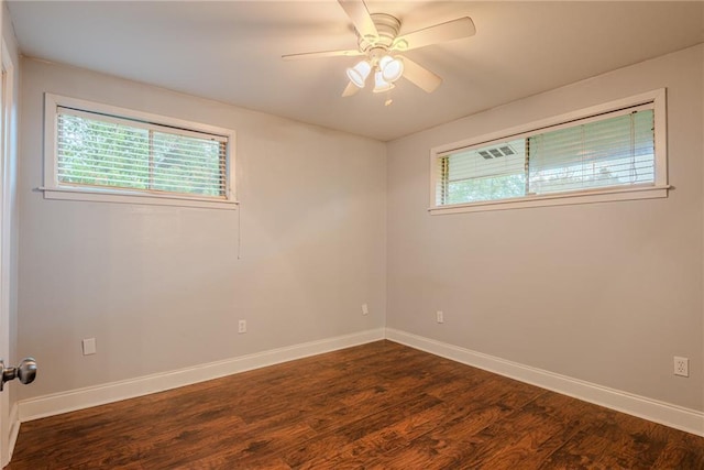 unfurnished room with a healthy amount of sunlight, baseboards, a ceiling fan, and dark wood-type flooring