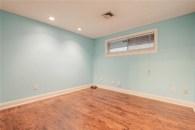 unfurnished room featuring baseboards, recessed lighting, wood finished floors, and visible vents