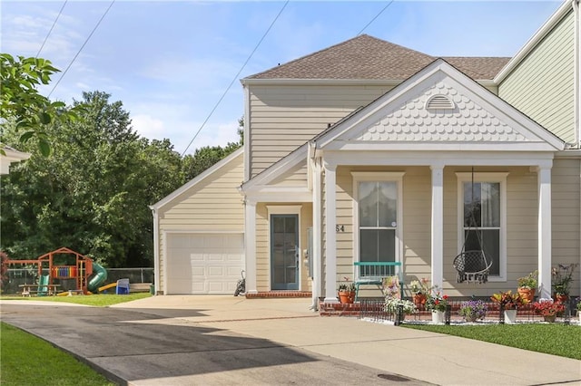 view of front facade featuring a garage, driveway, a shingled roof, and covered porch