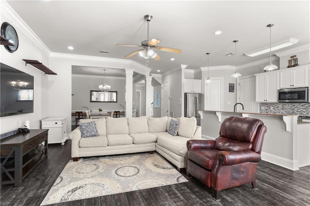 living area with visible vents, ornamental molding, dark wood-type flooring, recessed lighting, and ceiling fan with notable chandelier
