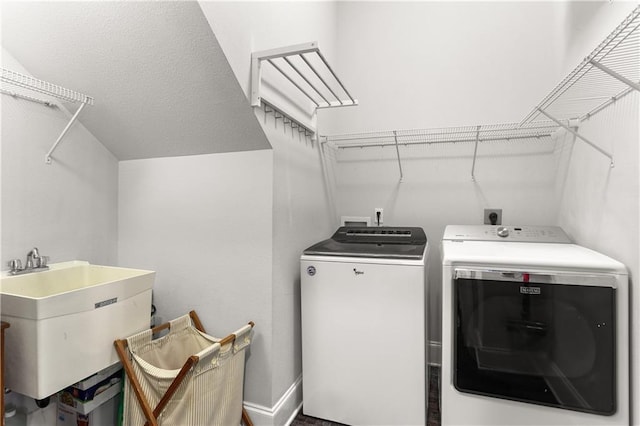laundry room with a sink, baseboards, laundry area, and independent washer and dryer