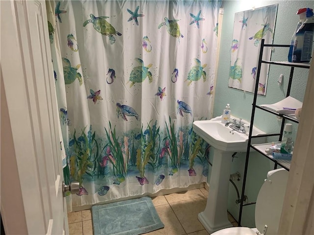 bathroom featuring tile patterned flooring, a textured wall, and shower / bathtub combination with curtain