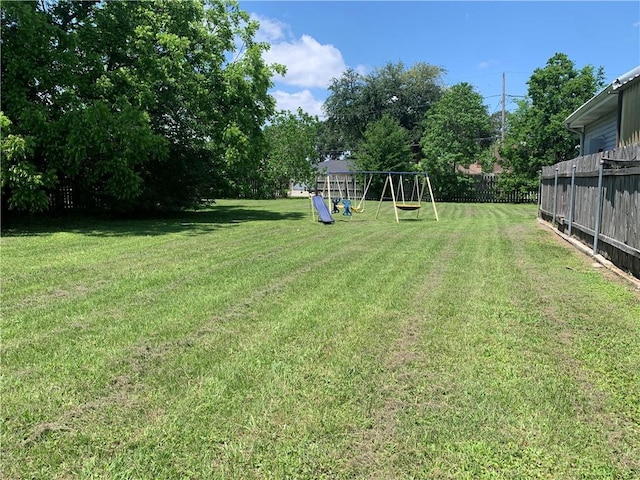 view of yard featuring fence and a playground