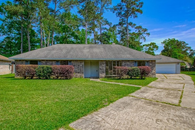 single story home featuring brick siding, a shingled roof, a front yard, and a detached garage
