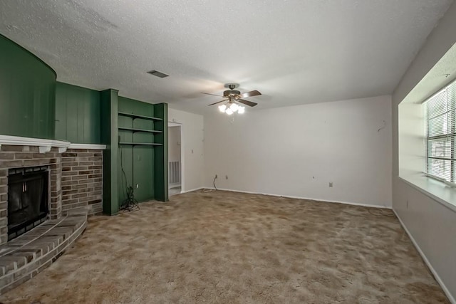 unfurnished living room featuring a brick fireplace, a ceiling fan, visible vents, and carpet floors