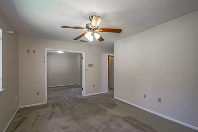 carpeted empty room featuring baseboards, a ceiling fan, and visible vents