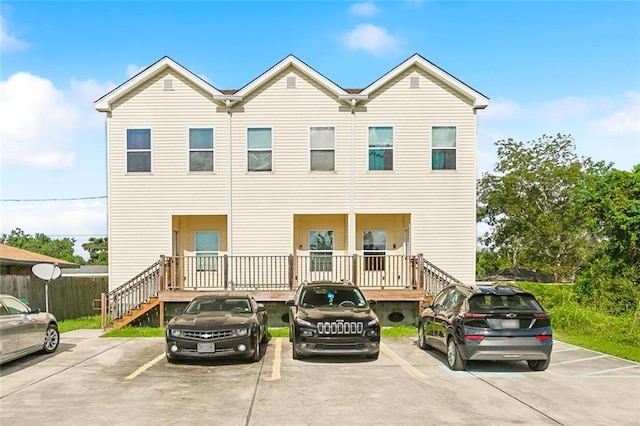 1209 Tallow Tree Ln, Harvey, LA 70058 - view of property featuring stairs, uncovered parking, and fence