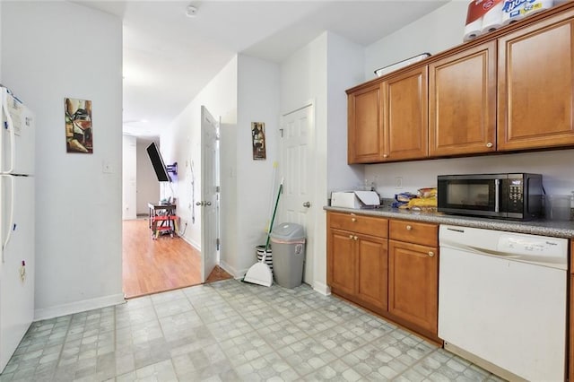 1209 Tallow Tree Ln, Harvey, LA 70058 - kitchen featuring brown cabinetry, light floors, baseboards, and white appliances