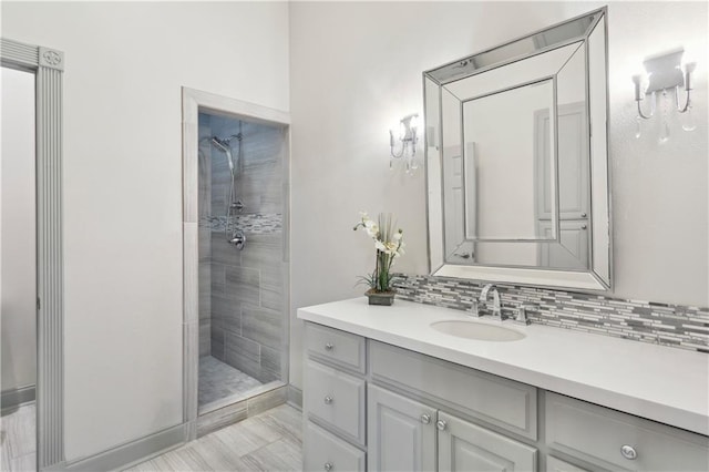 full bath featuring vanity, decorative backsplash, and tiled shower