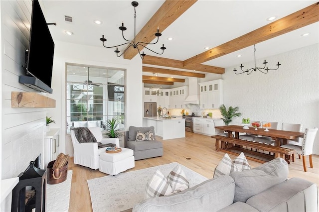 living area featuring beam ceiling, a chandelier, recessed lighting, light wood-type flooring, and visible vents