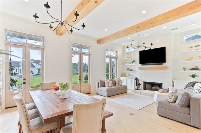 interior space with french doors, a large fireplace, beam ceiling, light wood finished floors, and recessed lighting