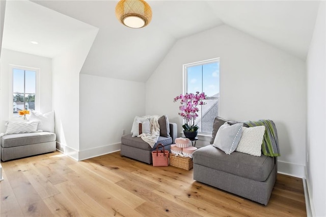 sitting room featuring baseboards, vaulted ceiling, plenty of natural light, and light wood-type flooring
