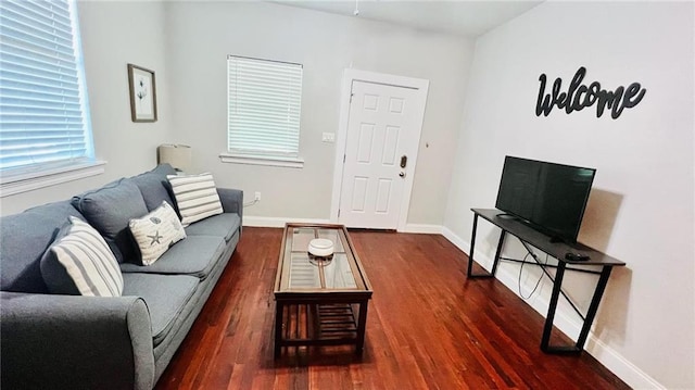 living area featuring baseboards and wood finished floors