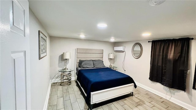bedroom featuring baseboards, wood tiled floor, a wall unit AC, and recessed lighting