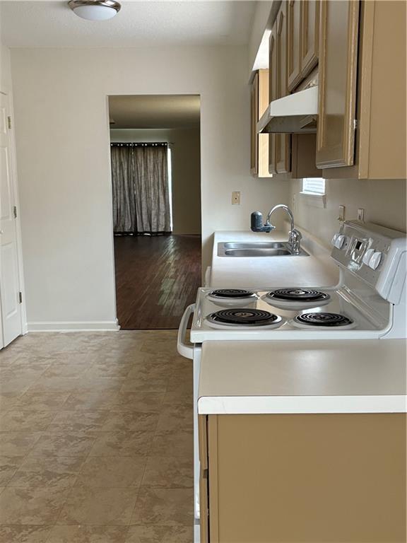 220002 Division St, Metairie, LA 70001 - kitchen featuring a sink, under cabinet range hood, white range with electric cooktop, and light countertops