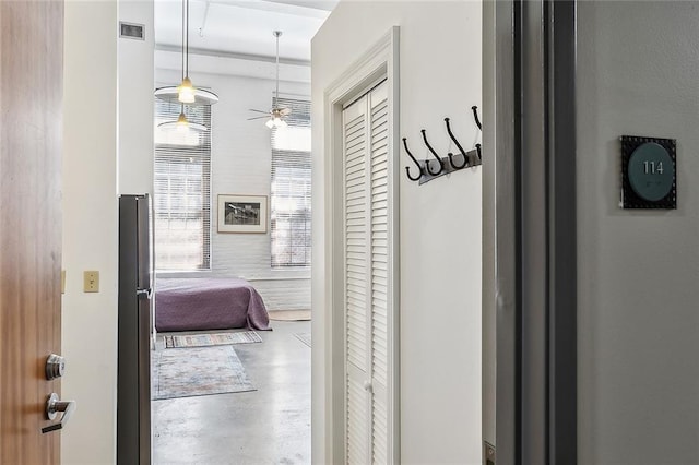 hall featuring visible vents and concrete floors
