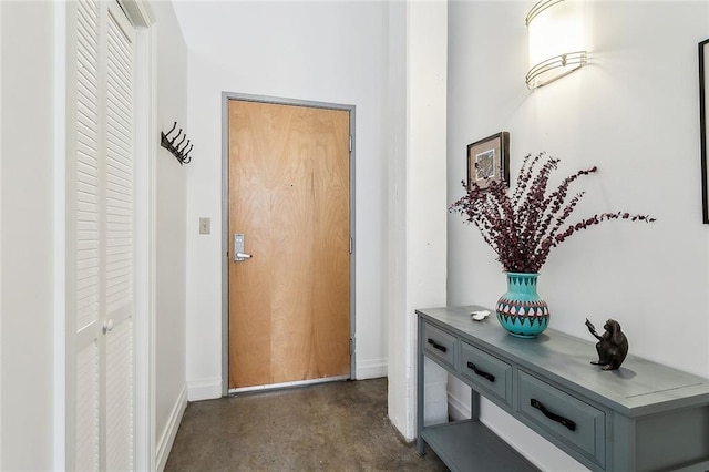 entryway with baseboards and concrete flooring