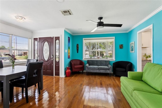 living room with wood-type flooring, a ceiling fan, crown molding, and visible vents