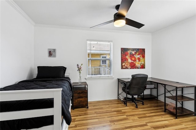 bedroom featuring baseboards, ornamental molding, and light wood finished floors