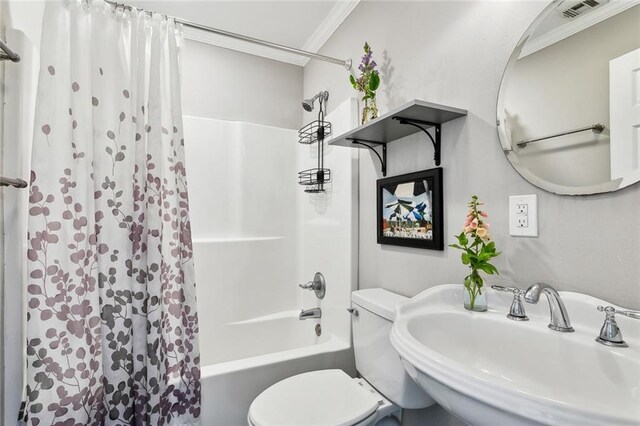 bathroom featuring visible vents, shower / tub combo, a sink, toilet, and ornamental molding