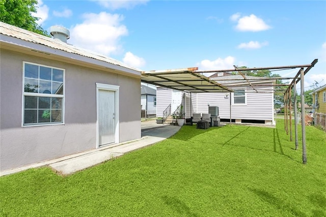 rear view of house with metal roof, a lawn, a pergola, entry steps, and stucco siding