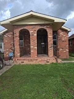 view of front of property with brick siding and a front lawn