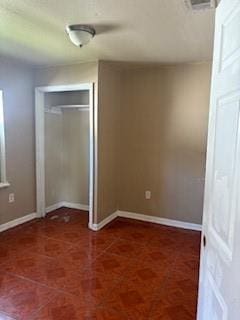 unfurnished bedroom featuring baseboards, a closet, and visible vents