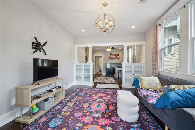 living room with an inviting chandelier, recessed lighting, baseboards, and wood finished floors