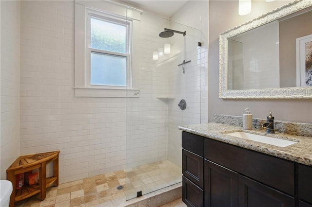 bathroom featuring a tile shower and vanity