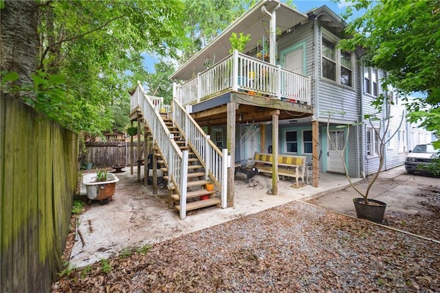 back of property with fence, an outdoor hangout area, a deck, stairway, and a patio