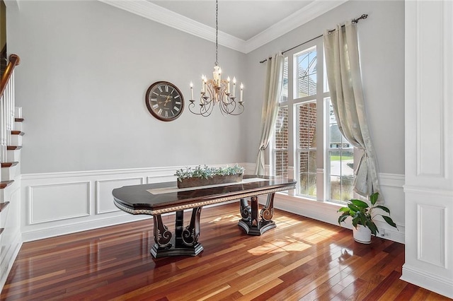 864 Sweet Bay Dr, Mandeville, LA 70448 - dining area featuring a chandelier, wood finished floors, crown molding, a wainscoted wall, and a decorative wall