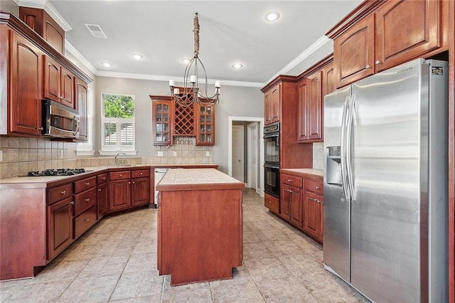 864 Sweet Bay Dr, Mandeville, LA 70448 - kitchen with appliances with stainless steel finishes, ornamental molding, a center island, tasteful backsplash, and glass insert cabinets