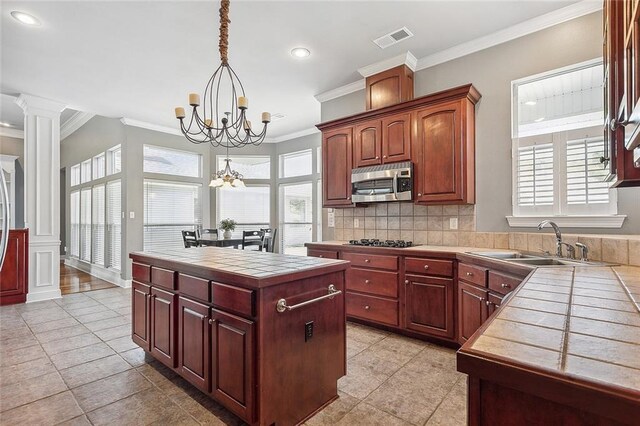 864 Sweet Bay Dr, Mandeville, LA 70448 - kitchen featuring stainless steel microwave, tile countertops, a chandelier, light tile patterned floors, and black cooktop