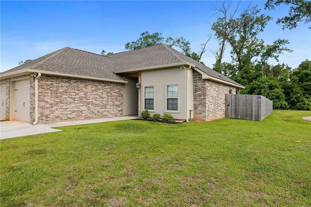 view of front facade with fence, brick siding, a garage, a front yard, and driveway