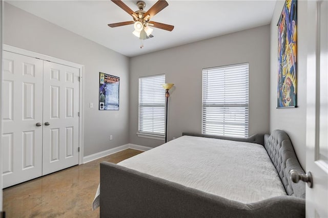 bedroom with baseboards, concrete floors, ceiling fan, and a closet