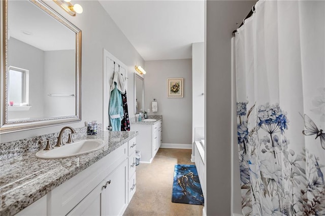 full bath featuring a sink, baseboards, curtained shower, and two vanities